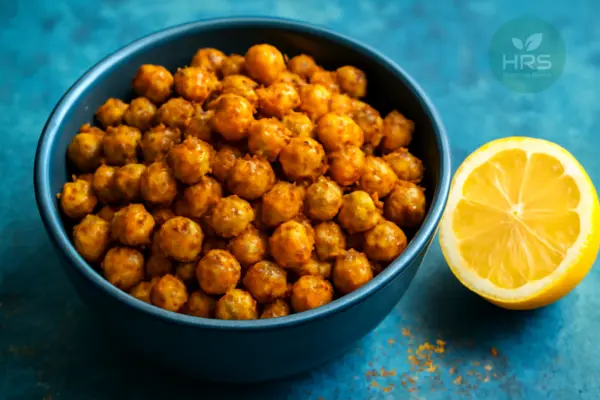 Indian-style roasted chickpeas in a bowl with spices and a halved lemon for vitamin C.